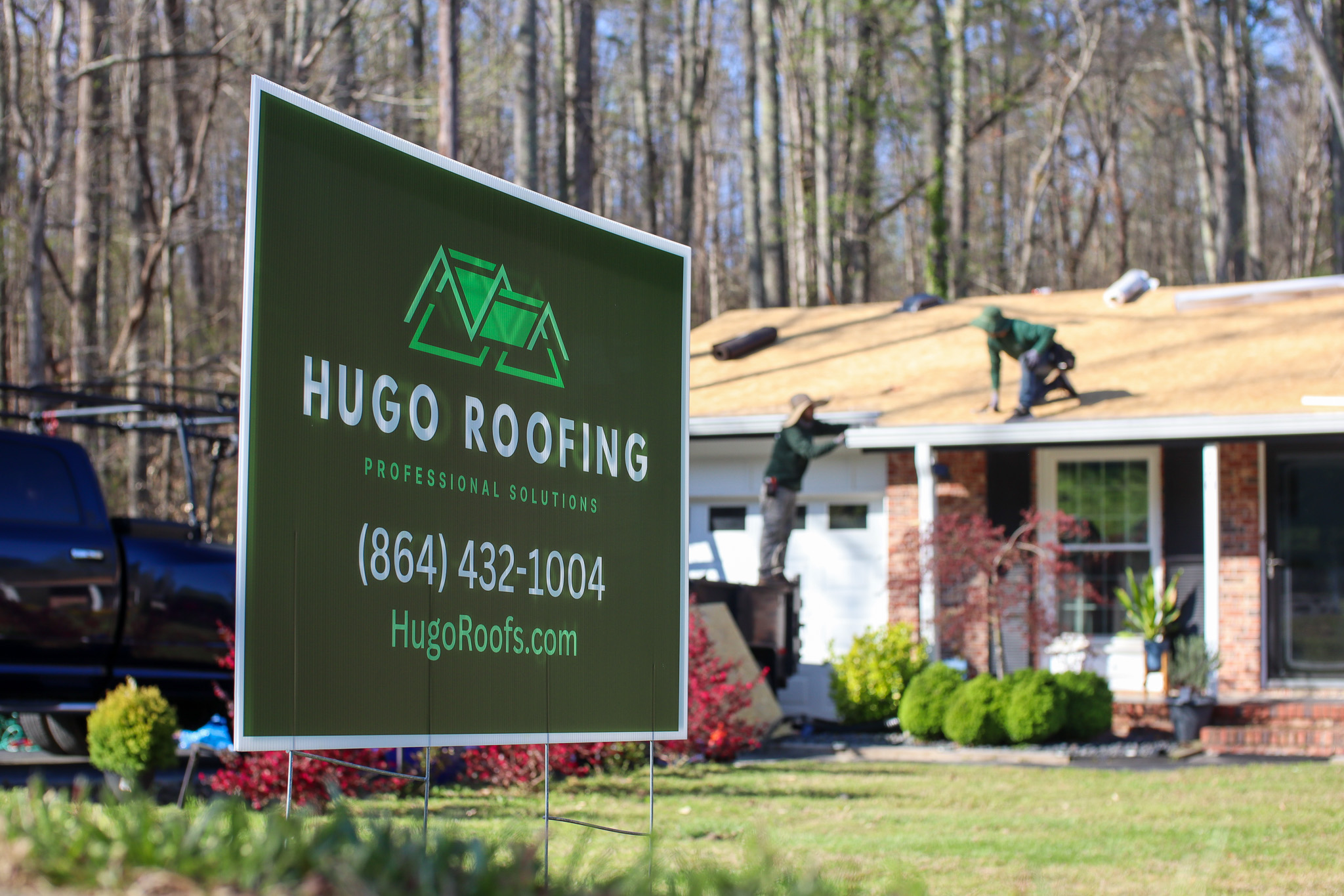 Hugo Roofing sign with roofing work in the background